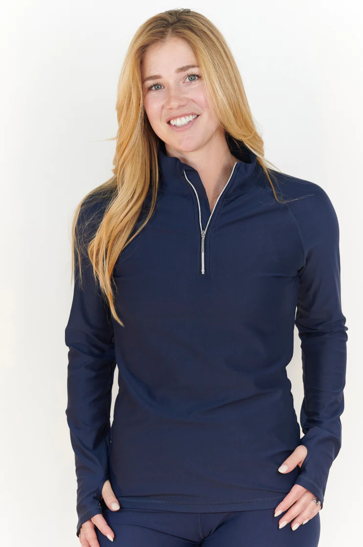 Woman wearing navy long-sleeve 1/4-zip top with wrist & finger holes