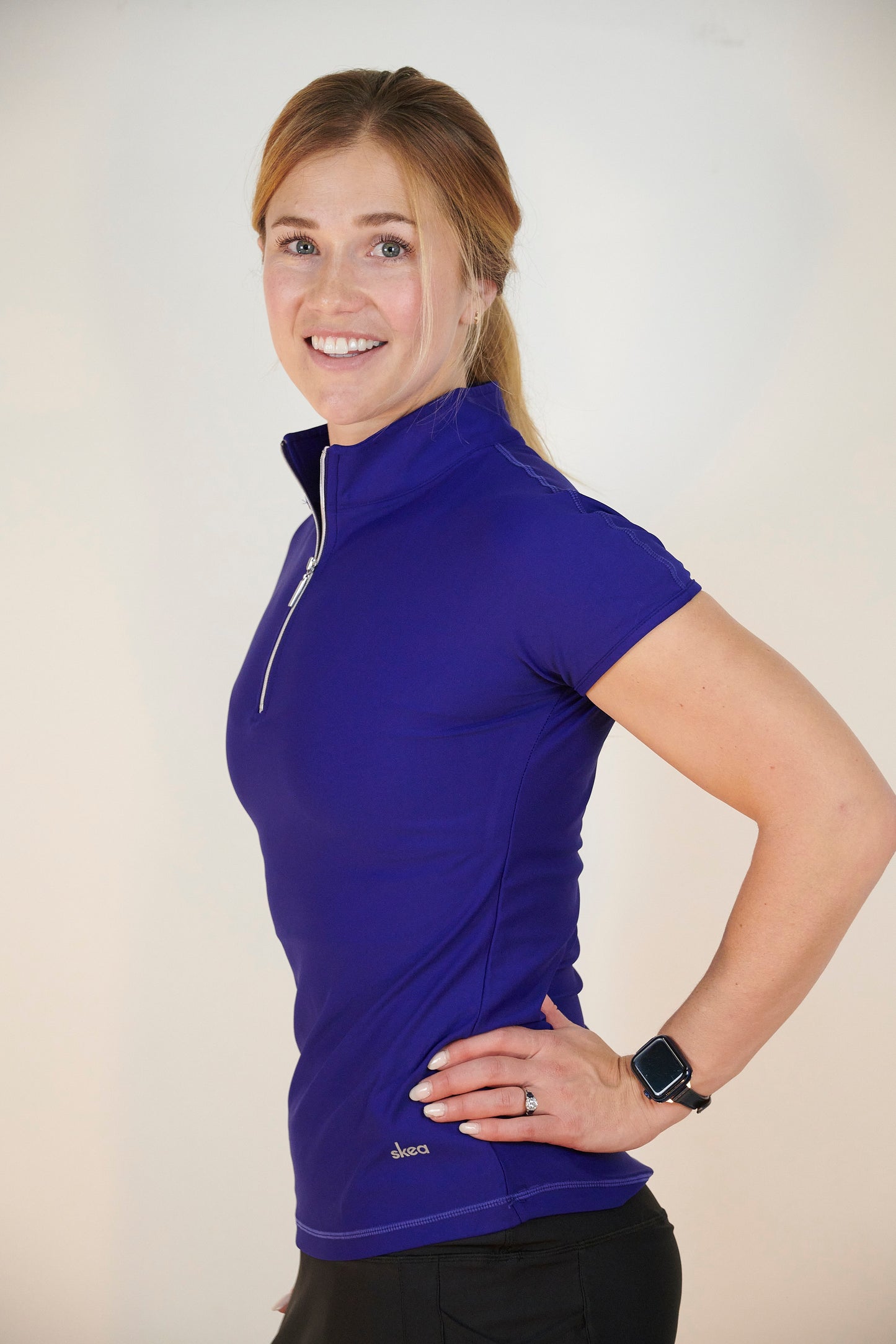 Woman in blue designer pickleball top with half zip closure