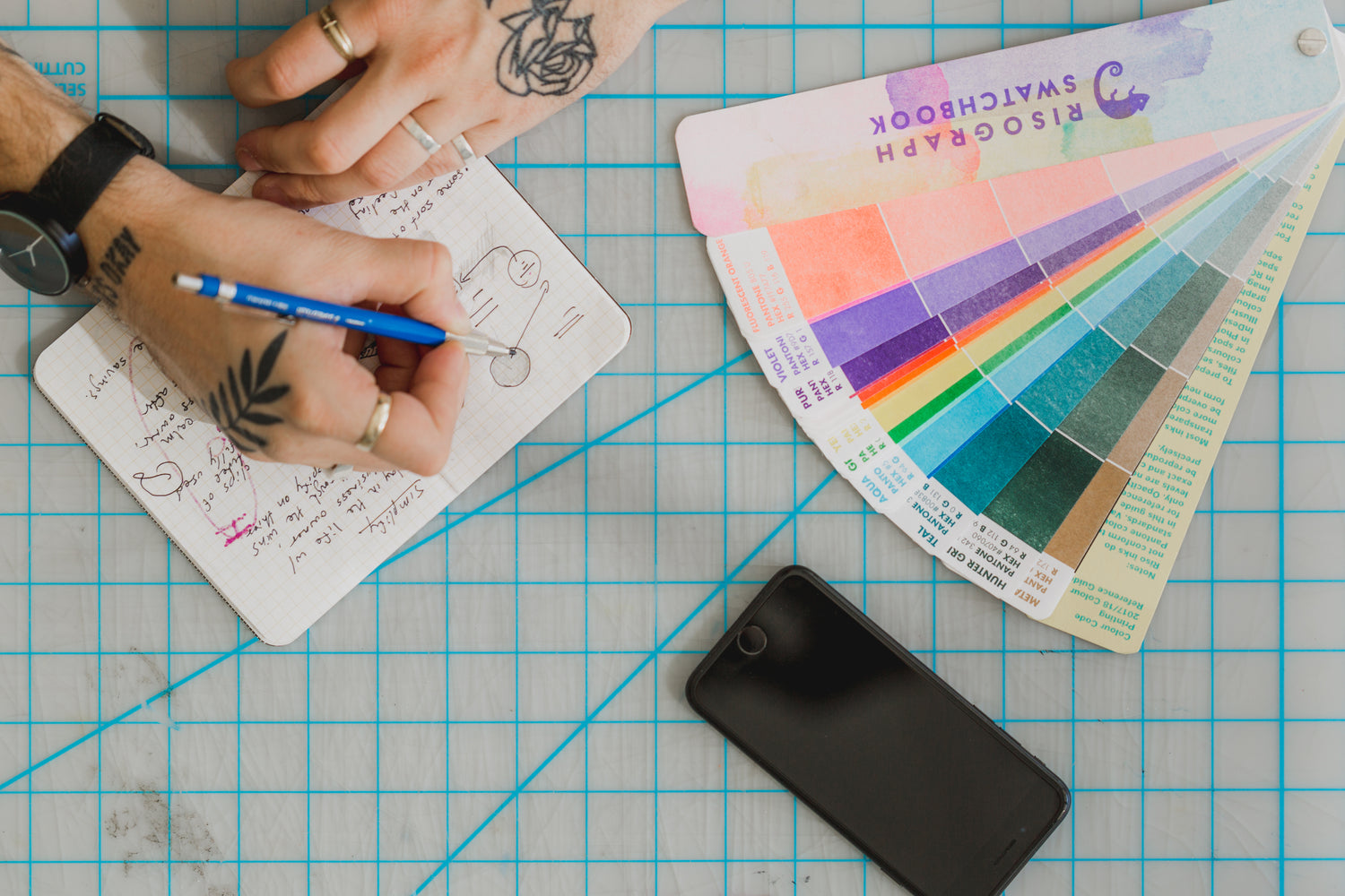 Artist with pencil and swatchbook designing pickleball bags