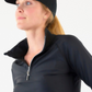 Woman in hat wearing black 1/4-zip top in black