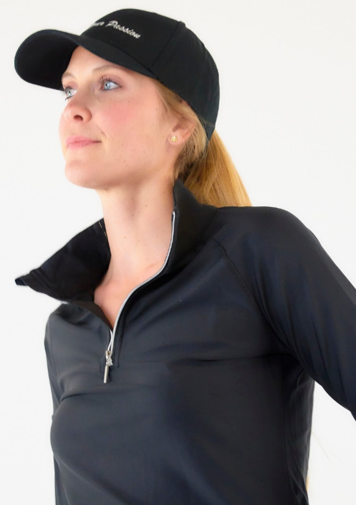 Woman in hat wearing black 1/4-zip top in black