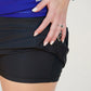 Black Skea Angelic skort and woman's hand raising skirt to show shorts