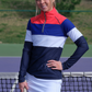Woman courtside wearing striped half zip top and white skort