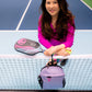 Woman on court wearing 1/4 zip pink top and holding women's designer pickleball tote