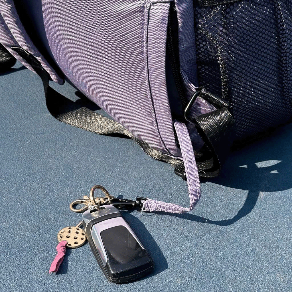 women's designer pickleball backpack featuring a hidden key pocket and a key leash attached.