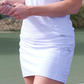 waist-view of woman in Skea white skort on tennis court