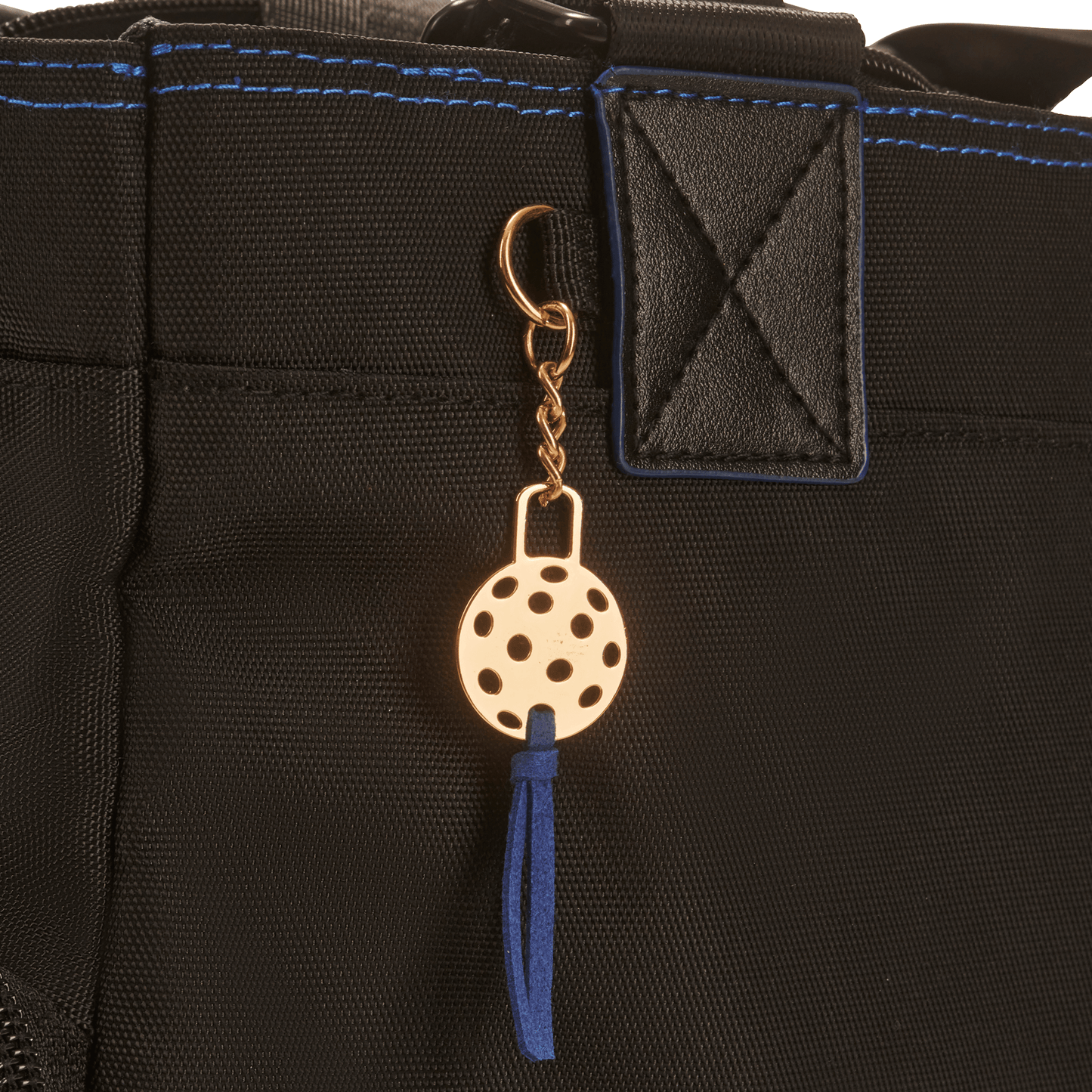 closeup of Black pickleball tote with gold pickleball tag & blue suede tassel 